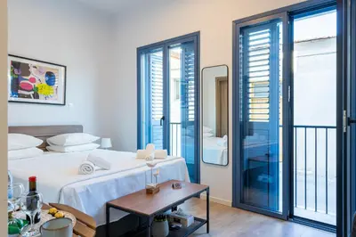 a hotel room with a bed and a balcony at Le Voyageur By the Sea - Furnished Rooms in Larnaka