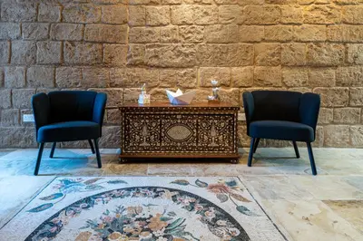 two chairs and a table in front of a brick wall at Le Voyageur By the Sea - Furnished Rooms in Larnaka