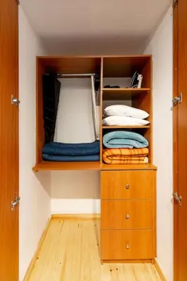 a closet with a wooden cabinet and some towels at Spacious studio located in the pedestrian zone in Nicosia