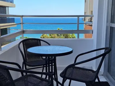 a table and chairs on a balcony with a view of the ocean at Luxury one bedroom - seafront in Limassol