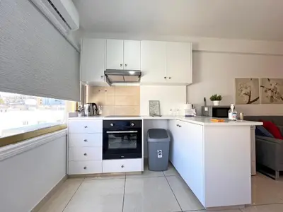 a kitchen with white cabinets and a stove top oven at Albert's Apartment Center 21 in Larnaka