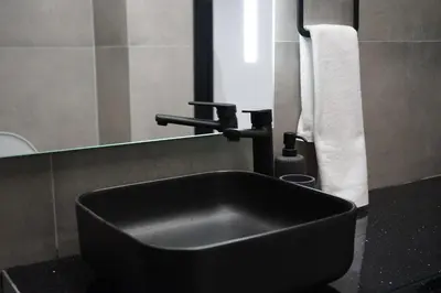 a bathroom with a black sink and a mirror at Lazuli Urban Luxury -2 bedroom with Pool in Larnaka