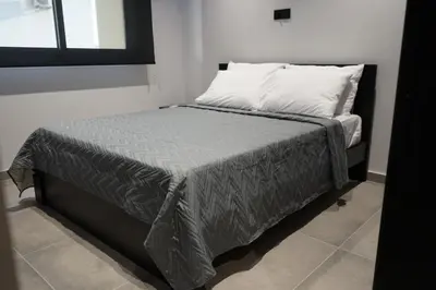 a bed with two pillows and a gray blanket at Lazuli Urban Luxury -2 bedroom with Pool in Larnaka