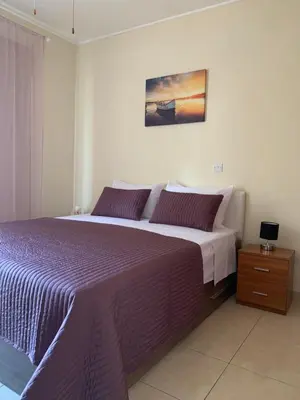 a bedroom with a large bed with a purple blanket at Seascape apartment in Larnaka