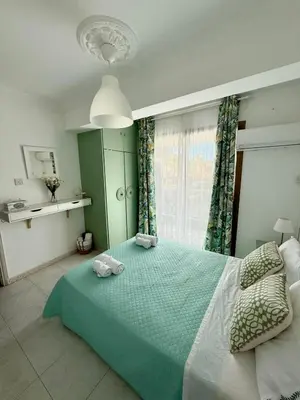a bedroom with a green bed with two towels on it at Irenes Apartment in Larnaka