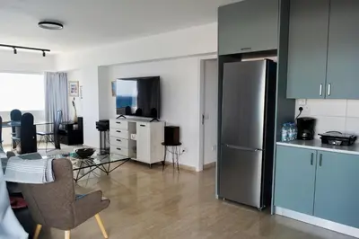a kitchen and a living room with a refrigerator at Stunning Top-Floor Beachfront Apartment in Larnaka
