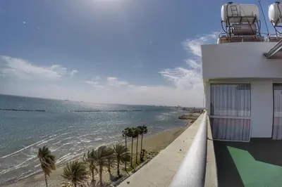 a view of the ocean from the balcony of a building at Stunning Top-Floor Beachfront Apartment in Larnaka