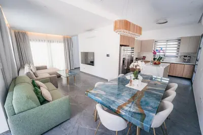 a living room with a couch and a dining table at TG NEW Luxury Private Resort & SPA Villas - Heated Salty Swimming Pool, Outdoor Jacuzzi, Sauna, Exotic Garden in Limassol