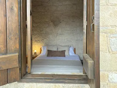 a bedroom with a bed in a stone wall at Levanda House - Traditional House Vasa Koilaniou in Vasa Kilaniou