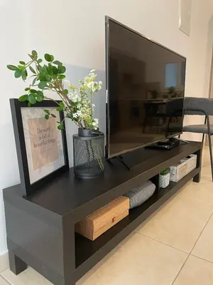 a black entertainment center with a flat screen tv at STAY Novel Apartment in Larnaka