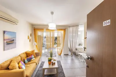 a living room with a yellow couch and a table at STAY Sunflower Delight Studio in Nicosia