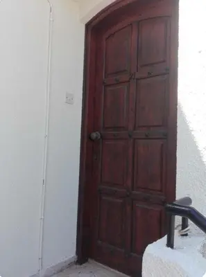 a wooden door in a room with a white wall at Sweet Home by the sea in Pyla