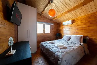 a bedroom with a bed in a wooden cabin at Ktima To Alliotiko - Lofou 2 in Lofou