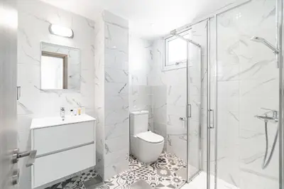 a white bathroom with a toilet and a shower at Villa Elite Blu by Ezoria Villas in Ayia Napa