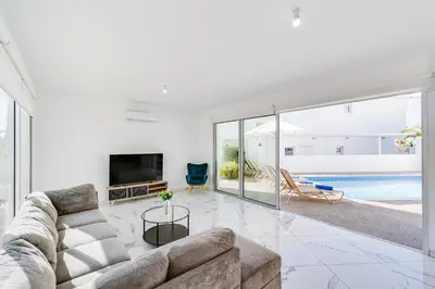 a living room with a couch and a tv at Villa Elite Blu by Ezoria Villas in Ayia Napa