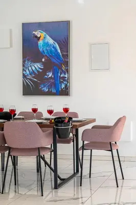 a dining room with a blue bird painting on the wall at Villa Elite Blu by Ezoria Villas in Ayia Napa