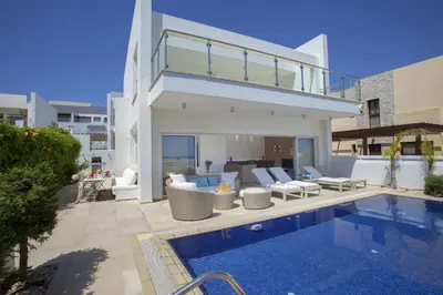 a villa with a swimming pool and a house at Goodness Villa offers Magnificent Coastal Views in Protaras