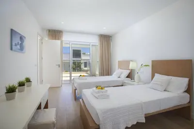 a hotel room with two beds and a couch at Goodness Villa offers Magnificent Coastal Views in Protaras