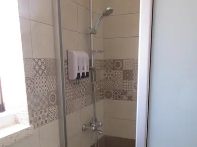 a shower with a glass door in a bathroom at Grandma's House in Liopetri