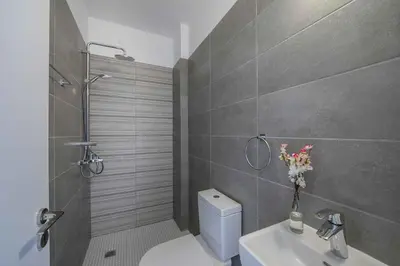 a bathroom with a shower and a toilet and a sink at Brand New Luxurious Villa With Pool in Protaras