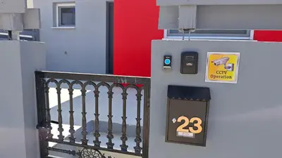 an entrance to a building with a gate and a clock at Modern 1-bedroom home in Larnaca with a private garden ideal for long stays and remote work in Larnaka