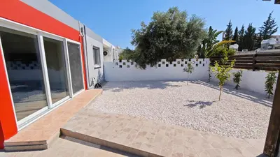 a courtyard of a house with a fence and trees at Modern 1-bedroom home in Larnaca with a private garden ideal for long stays and remote work in Larnaka