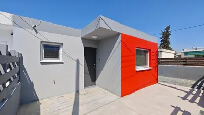 a house with a red door on the side of it at Modern 1-bedroom home in Larnaca with a private garden ideal for long stays and remote work in Larnaka
