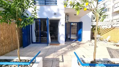 a house with blue doors and two chairs at Boho Greek Haven with Orange Grove Views Near Beach in Larnaka