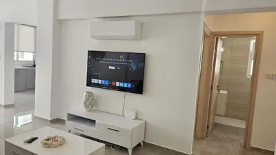 a living room with a tv on a white wall at STAY Local Apartment in Larnaka