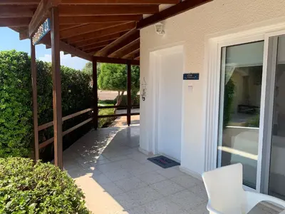 a porch of a house with a white chair at Ayia Napa - Ayia Thekla Sea View Beach Villa in Ayia Napa