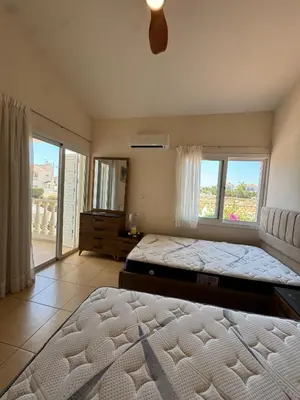 a bedroom with two beds and a large window at Villa Dafni Malama in Paralimni