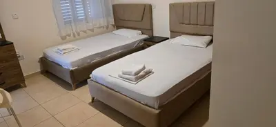two beds in a hotel room with towels on them at Villa Dafni Malama in Paralimni