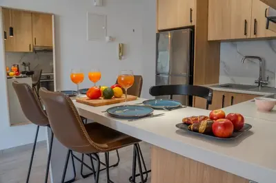 a kitchen with a table with fruit and wine glasses at Beautiful One Bedroom Apartment, 186 Meters to Beach, Central Location Next to Cafes & Bars in Limassol