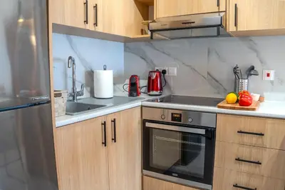 a kitchen with a sink and a stove top oven at Beautiful One Bedroom Apartment, 186 Meters to Beach, Central Location Next to Cafes & Bars in Limassol
