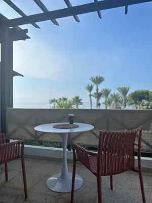 a table and two chairs with a drink on a patio at Yialos Village by Cybarco in Larnaka