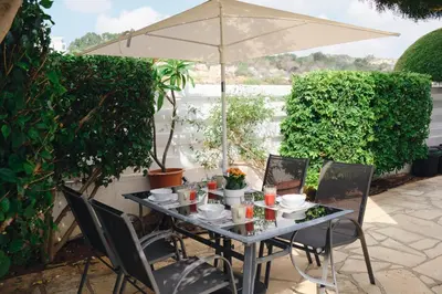 a table with chairs and an umbrella on a patio at Soleil Residence - Charming 2BR Holiday House with Garden at Protaras - Konnos Area in Protaras