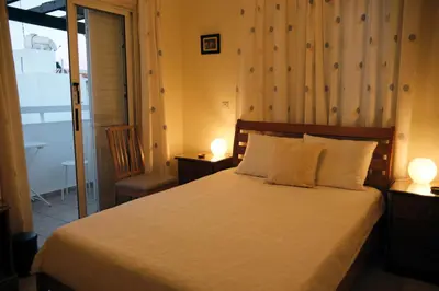 a bedroom with a bed with two lamps and a window at Soleil Residence - Charming 2BR Holiday House with Garden at Protaras - Konnos Area in Protaras