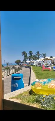 a park with a boardwalk and a beach with a trash can at Relax by the sea in Protaras