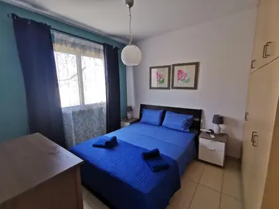 a bedroom with a blue bed and a window at Relax by the sea in Protaras