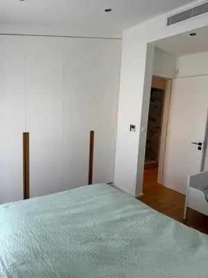 a white bedroom with a bed and a chair at Larnaca Centre Villa in Larnaka