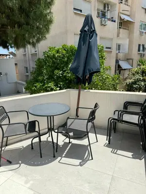a patio with a table and chairs and an umbrella at Larnaca Centre Villa in Larnaka