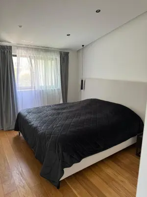 a bedroom with a bed with a black comforter at Larnaca Centre Villa in Larnaka