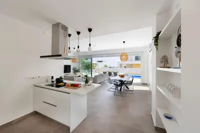 a kitchen with white cabinets and a dining room at Protaras Bay View Villa 11 in Protaras