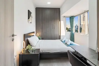 a bedroom with a bed and a desk and a window at Heart Of Nicosia - The Gem in Nicosia