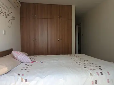 a bedroom with a large white bed with wooden cabinets at Kiti 2 bedroom Penthouse in Kiti
