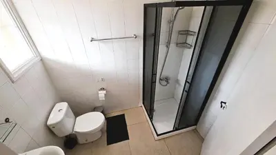 a bathroom with a toilet and a glass shower at Lovely 1BR in Old Town - City Center & 4min to Beach in Scala