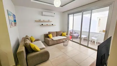 a living room with a couch and a large window at Seaside Comfort Residence in Larnaka