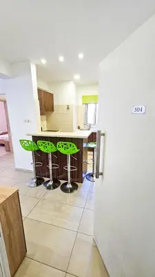 a kitchen with a counter and stools in a room at Seaside Comfort Residence in Larnaka