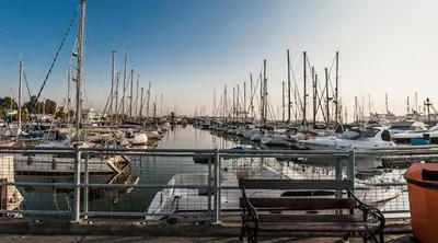 a dog sitting on a railing at a marina at Seaside Comfort Residence in Larnaka