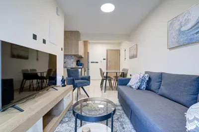 a living room with a blue couch and a table at 75 Prokymea- Steps from the Sea, Downtown, Balcony in Limassol